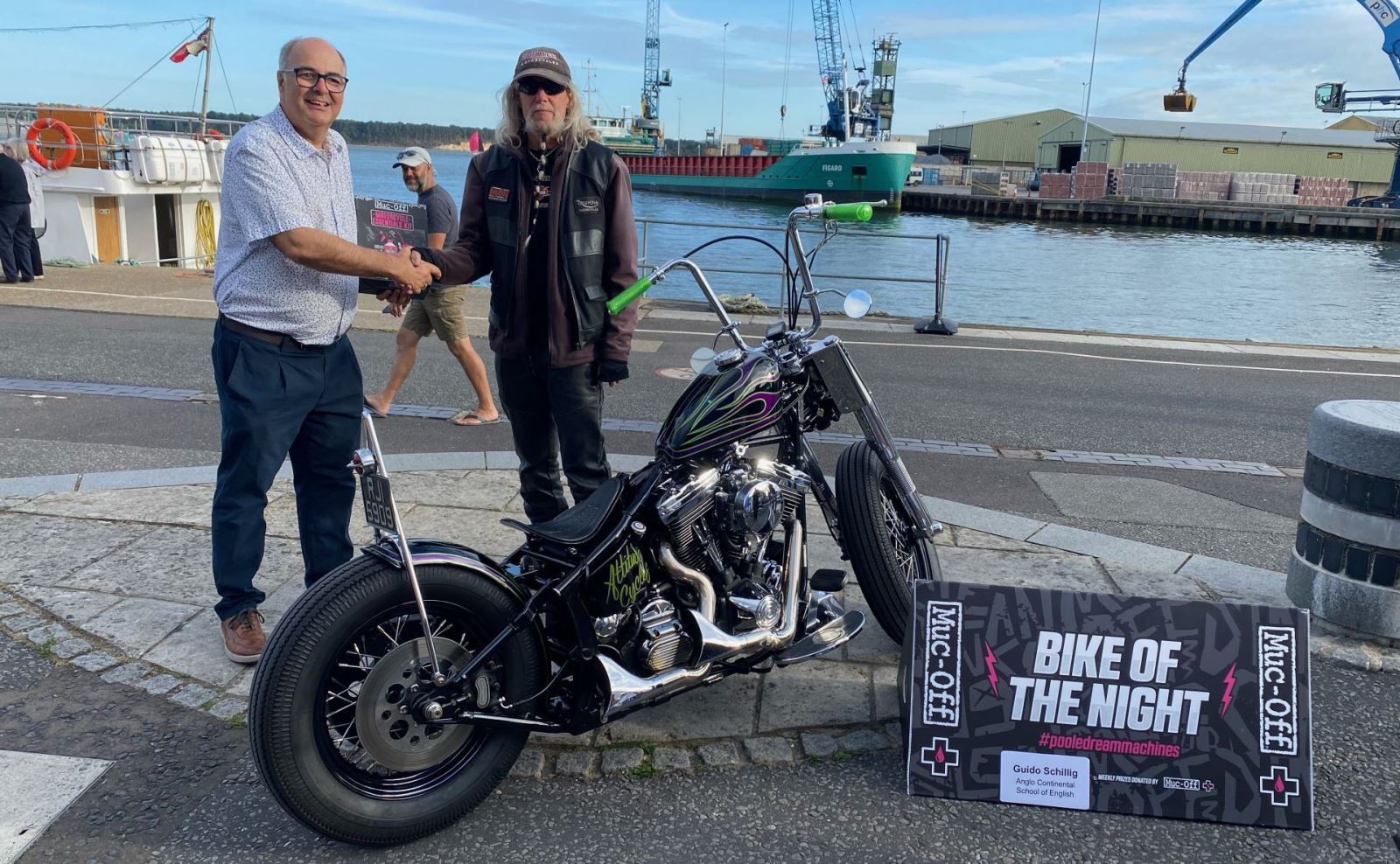 Two men shaking hands on Poole Quay during bike night